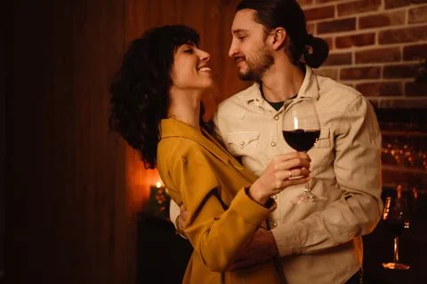 White romantic couple dancing while drinking wine at home Stock Photos