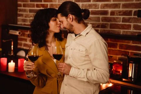White romantic couple hugging while drinking wine at home Stock Photos