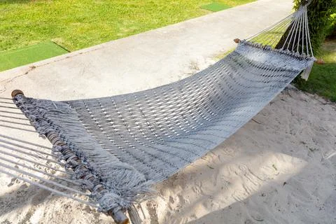 A white rope hammock is on the ground Stock Photos