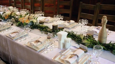 White roses with greenery stand on the festive served dinner table Stock Footage 65502740