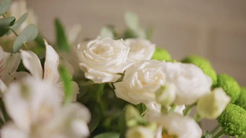 White roses on kitchen table, soft warm light, green button mums and eucalyptus Stock Footage 348298773