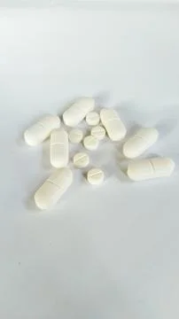 White round and oblong pills on white background Stock Photos