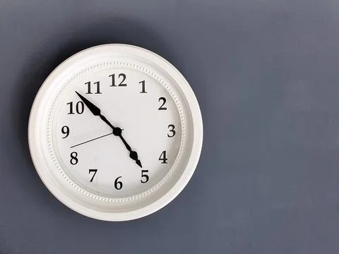 A white round clock on a gray background. Space for the text. Copy space Stock Photos