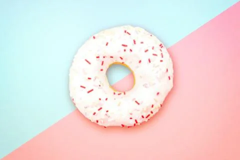 White round doughnut on blue background. Flat lay, top view. Stock Photos