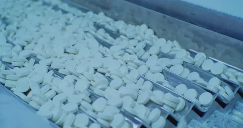 White round pills move on the modern pharmaceutical production line Stock Footage 165588349