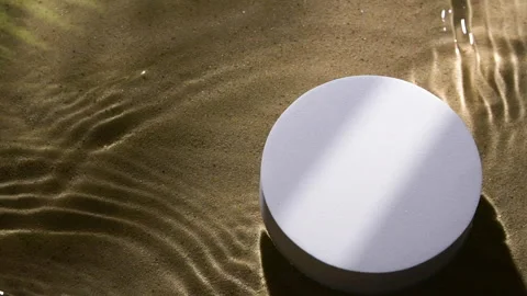 White round podium on sand and water wave, ripple, splash and tree leaf shadow Vídeo Stock 259370985