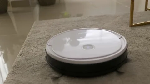 White round robot vacuum cleaner cleaning carpet floor. Stock Footage 203962908