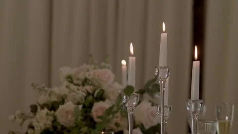 White round rough candles stand on candlesticks on the table and burn brightly. Stock Footage 236057797