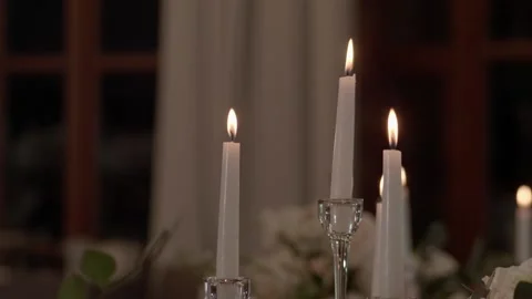 White round rough candles stand on candlesticks on the table and burn brightly. Stock Footage 236058229