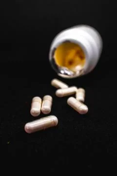 White round supplement pills falling out a bottle Stock Photos