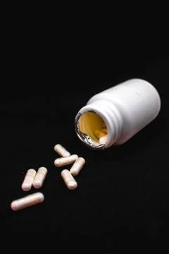 White round supplement pills falling out a bottle Stock Photos