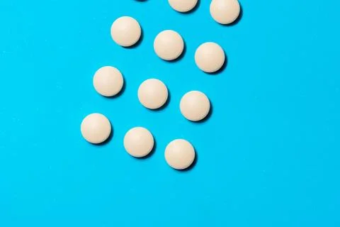White round tablets on a blue background. Stock Photos