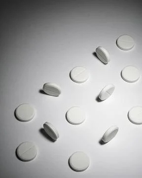 White round tablets scattered on surface creating minimal background for Stock Photos