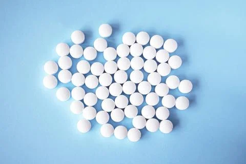 White round tablets, supplements on a blue background. Magnesium vitamins Stock Photos