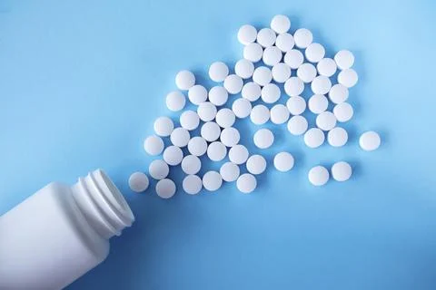 White round tablets, supplements with a can on a blue background. Magnesium Stock Photos