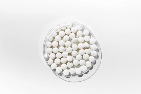 White round tablets on a white background. Tablets, minerals and vitamins. Stock Photos