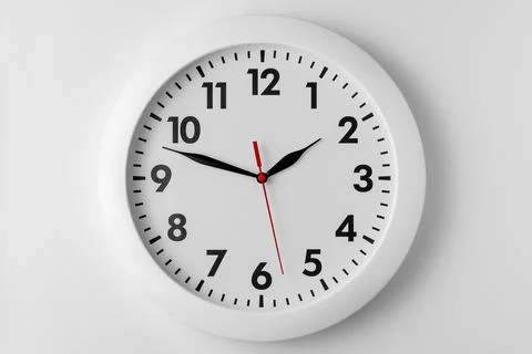 White round wall clock isolated on light gray background, natural shadow Stock Photos