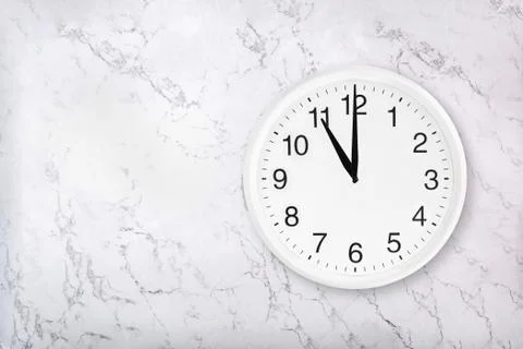 White round wall clock on white natural marble background Stock Photos