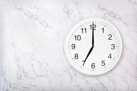 White round wall clock on white natural marble background Stock Photos