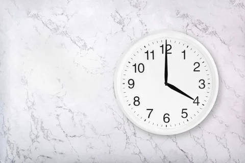 White round wall clock on white marble background Stock Photos