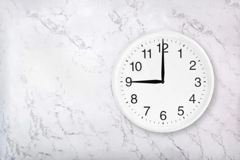 White round wall clock on white marble background Stock Photos
