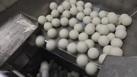 White Rubber Baseballs Vibrating Across Sorting Tray Into Hopper Vídeo Stock 339736723