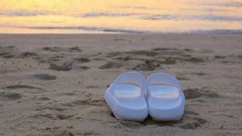 White rubber slippers on sandy beach at beachfront with blue sky landscape ocean Stock Footage 220187170