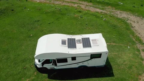 White rv with solar panels camping in a green meadow Stock Footage 344956389