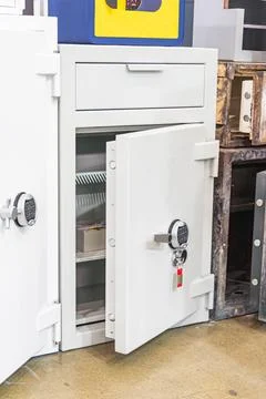 White safe with digital keypad lock open, revealing metal interior with she.. Stock Photos