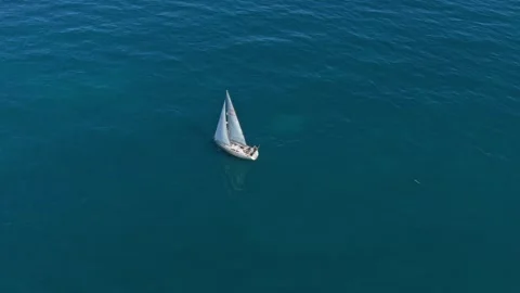White sailboat navigating across the open ocean aerial view 库存影片 330420839