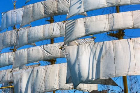 White Sails and Rigging of a Tall Ship Against Blue Sky 库存照片