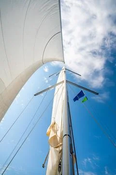 White sails filled with wind, seen from the bow of a sailing yacht near Croatia Stock Photos