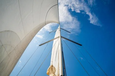 White sails filled with wind, seen from the bow of a sailing yacht near Croatia Stock Photos