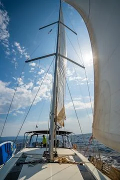 White sails filled with wind, seen from the bow of a sailing yacht near Croatia Stock Photos