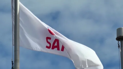 A white SAIT institutional flag featuring the colorful logo waves Stock Footage 334602266