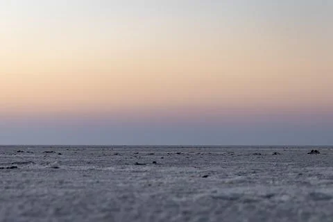 White salt flats desert with dramatic orange sunset sky at dusk 库存照片