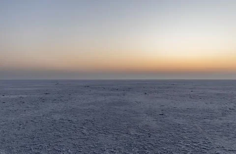 White salt flats desert with dramatic orange sunrise sky at dawn 写真素材