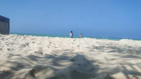 White sand blown by the beach breeze with people who like to Video stock 243431391