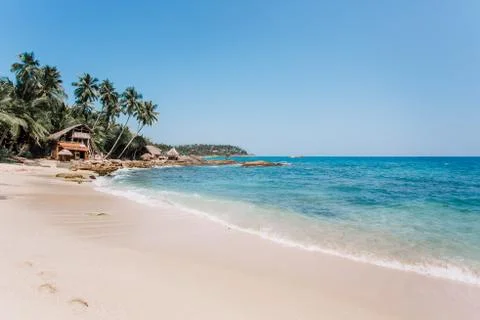 White sand & blue water in Tangalle. Goyambokka beach with palm & house on th Stock Photos