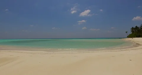 White sand of idyllic beach surrounding a calm lagoon with emerald water 스톡 동영상 118243120