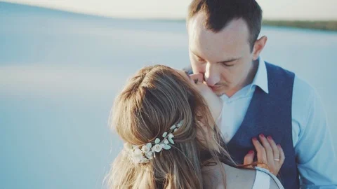 White sand smoothly turns into a train of white dress. A loving couple embraces Stock Footage 103585651