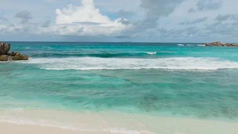 White sandy beach and turquoise sea on a cloudy day. La Digue, Seychelles. Stock Footage 314028544