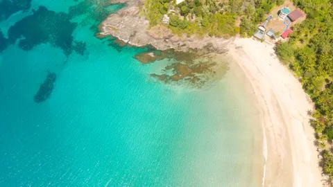 White sandy beach with palm trees and a beautiful lagoon. Stock Photos