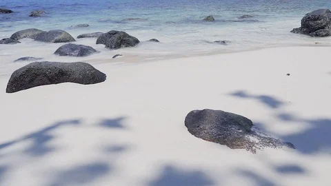 White sandy beach with rocks and clear blue water Stock Footage