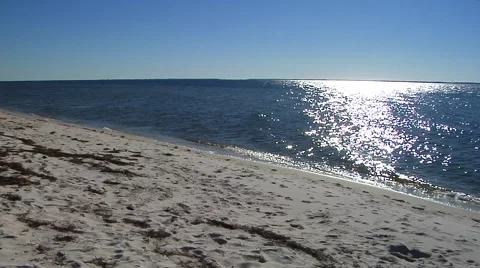  White sandy beach, slow pan right, sun reflection sparkles Stock Footage 57703580
