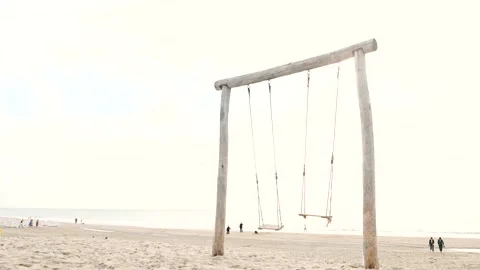 White, sandy beach at sunset. Slow motion of wooden swings. Sea or ocean Stock Footage 199982409