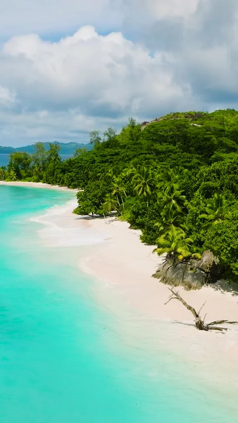 White sandy beach with turquoise water and lush greenery. Seychelles, Mahe. Stock Footage 303529930
