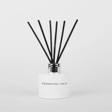 White scent diffuser bottle isolated with black reeds Foto stock