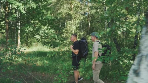 White scout moving through undergrowth and brush while partner follows on trail Stock Footage 323492496