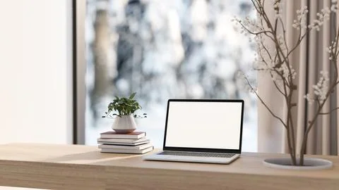 White screen computer and books with dried branch through wooden table and .. Illustrazione stock